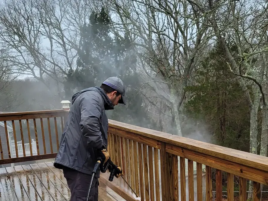 Power washing a wooden deck at a home in Cape Cod, MA